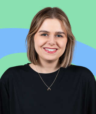 Smiling young woman with short blonde hair wearing a black shirt and crescent moon necklace.