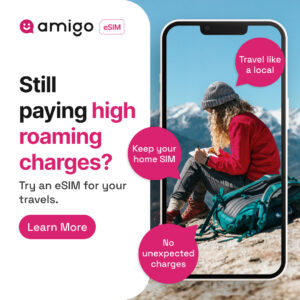 Reklama Amigo eSIM pyta: Nadal płacisz wysokie opłaty roamingowe? Kobieta w czapce pisze w górach, obok hasła: Podróżuj jak lokalny, zachowaj swój SIM domowy, bez niespodziewanych opłat. Przycisk: Dowiedz się więcej.