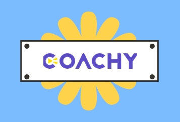 Logo Coachy: fioletowy napis "COACHY" na białym prostokącie z żółtym, stylizowanym kwiatem w tle, na jasnoniebieskim tle.