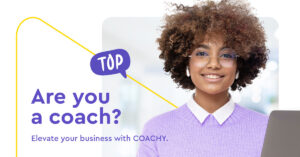 Uśmiechnięta kobieta z kręconymi włosami i okrągłymi okularami, ubrana w lawendowy sweter, obok tekstu: "Are you a coach?"