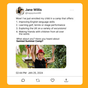 Uśmiechnięty chłopiec w czerwonym kasku na placu linowym trzyma łańcuchy. Zdjęcie z posta o obozie letnim.