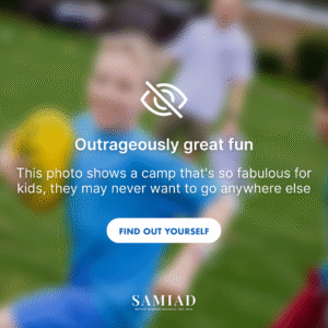 Rozmyte zdjęcie chłopca w niebieskiej koszulce bawiącego się żółtą piłką na zewnątrz, z tekstem "Outrageously great fun".