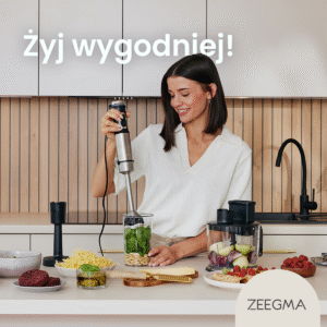 Uśmiechnięta kobieta używa blendera ręcznego do robienia pesto z bazylii i orzeszków piniowych w nowoczesnej kuchni.