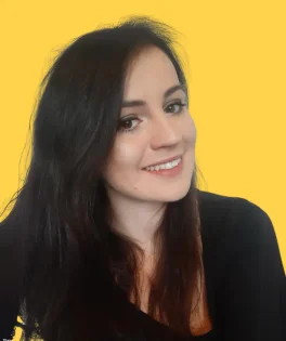 Smiling woman with long, dark hair, against a solid yellow background.