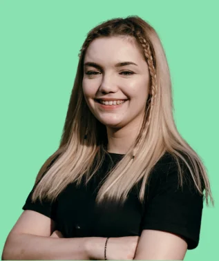 Smiling young woman with long blonde hair and small braids, dressed in black, against a light turquoise background.