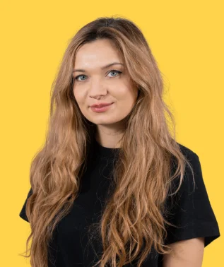 Portrait of a smiling woman with long, wavy light brown hair, against a solid yellow background.