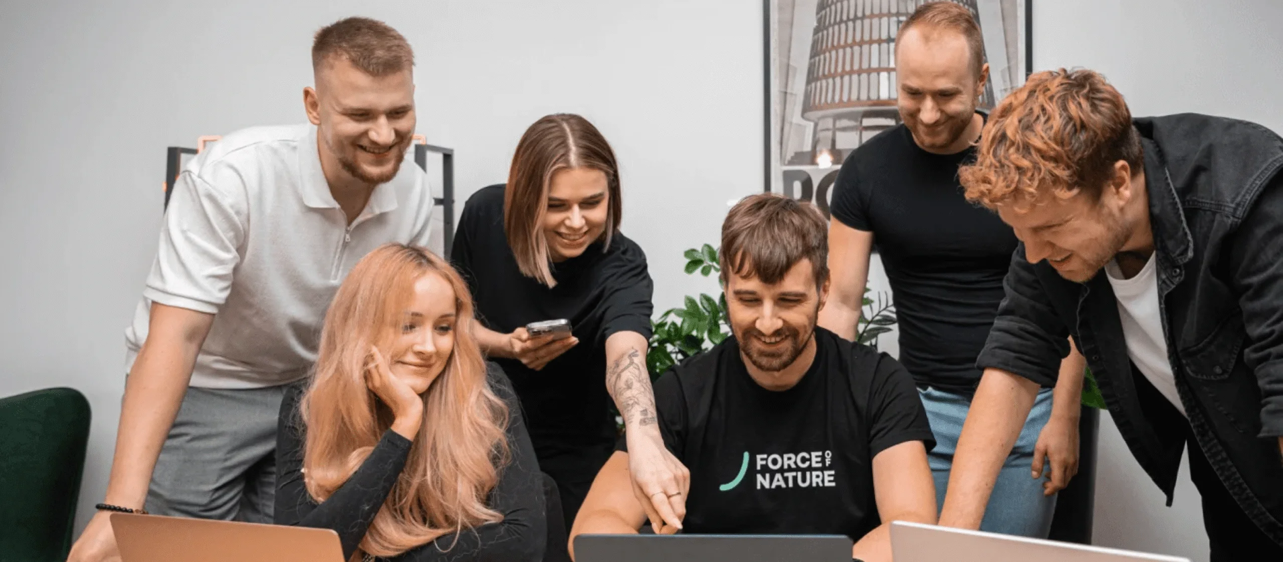 Uśmiechnięty zespół .mta wspólnie pracuje przy laptopie w biurze